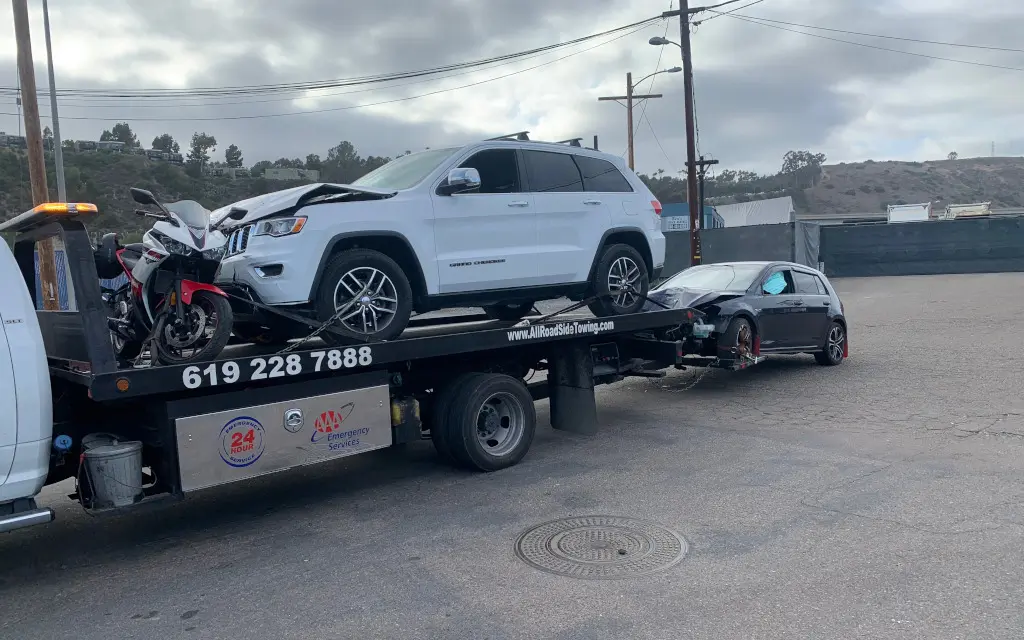 Towing service, cars on a Flatbed and a motorcycle. Triple up with All Roadside Towing.