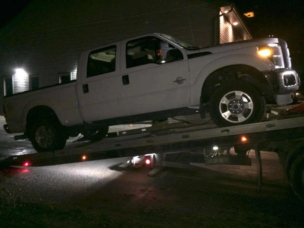 Nice new Ford Powerstroke being winched onto the deck by a Flatbed Tow Truck.